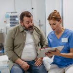 Female doctor consulting with overweight patient, discussing test result in doctor office. Obesity